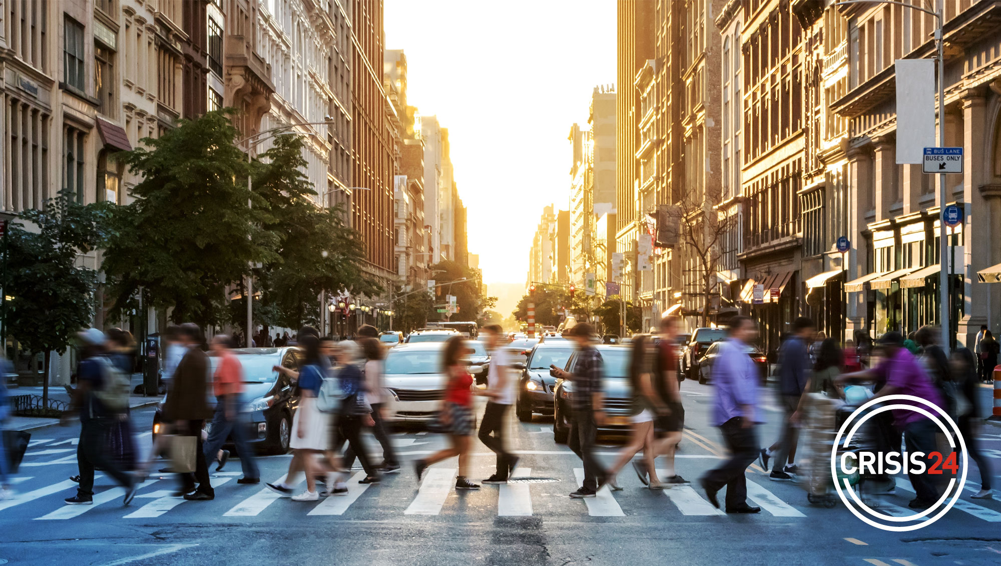 busy intersection with people in crosswalk with Crisis24 logo